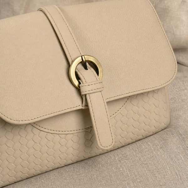Detail van de messing ringsluiting en het gevlochten leer van de Beocca Lua in beige
