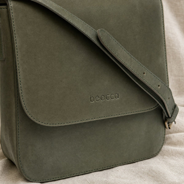 Detail van de klep, schouderband en het gedeboste logo van de Beocca Niba in groen