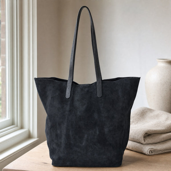 Beocca Mira shopper in zwart suede op een eikentafel bij het raam